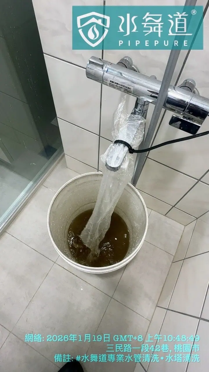 浴室淋浴管道清洗作業進行中，深褐色的排出水流經透明收集袋進入收集容器，展示管線內部鏽蝕物質的清洗過程