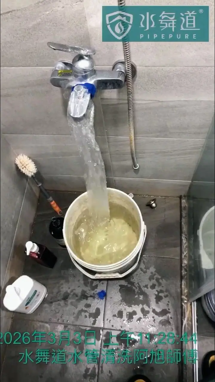 浴室淋浴龍頭正以高週波脈衝技術清洗，大量帶有白色懸浮物的混濁水流入桶中。