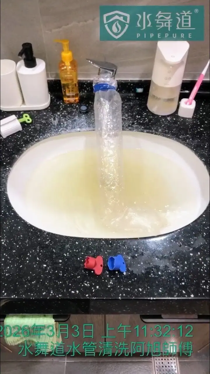 浴室洗手台在水管清洗過程中，充滿了因沖出管內積垢而呈現混濁黃色的水。
