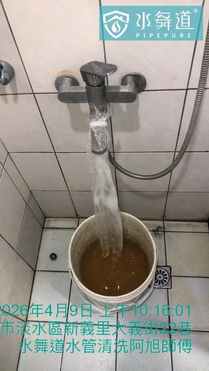 浴室出水端進行熱水管清洗排放，桶內呈現深褐色鏽垢沉積狀態