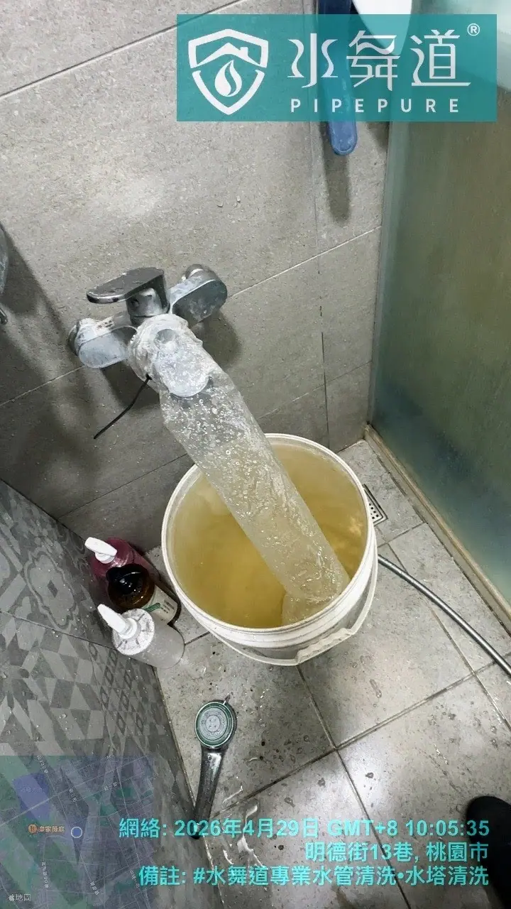 范師傅於淋浴間水龍頭接上透明套管，沖出老舊管線內積垢